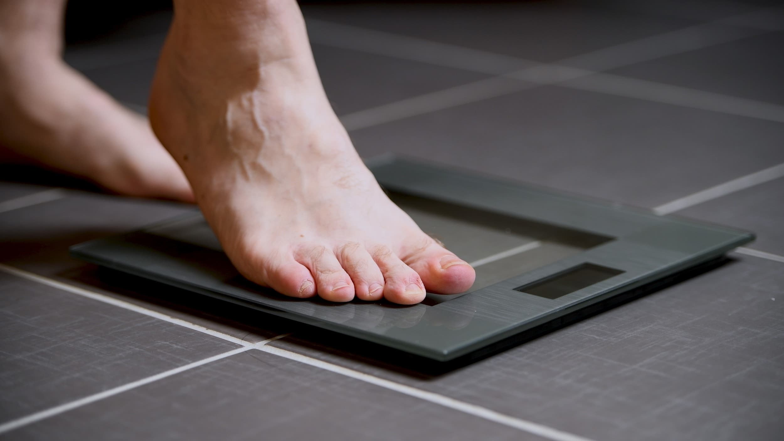 Man steps on a digital scale to check his weight