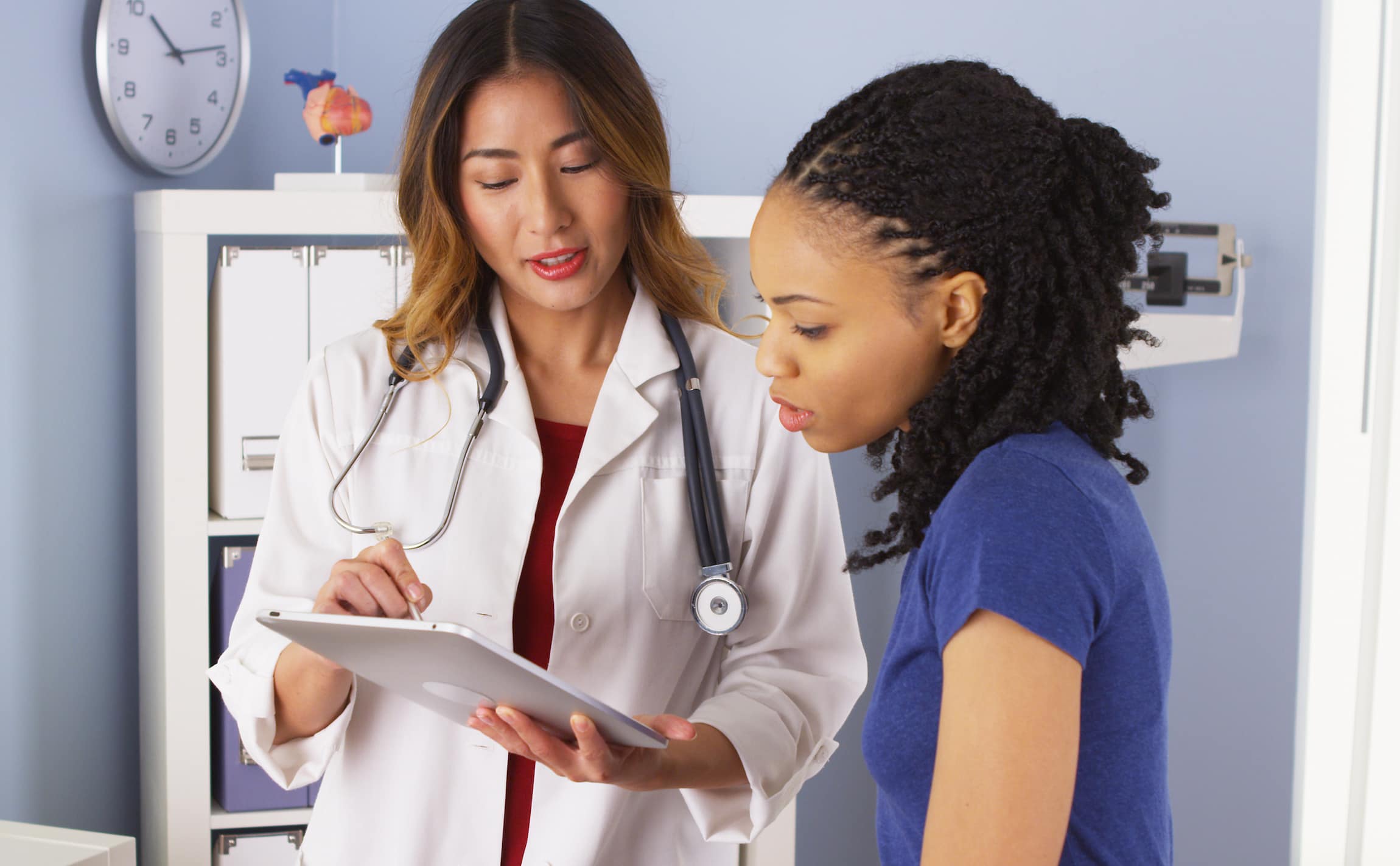 Doctor explaining the in vitro fertilization process to the patient using an ipad