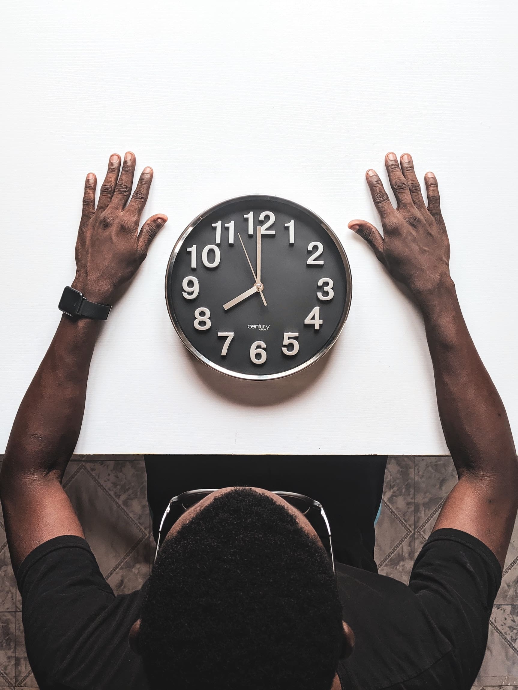 Man looking at a clock on the table waiting for the best time of day to test sperm count