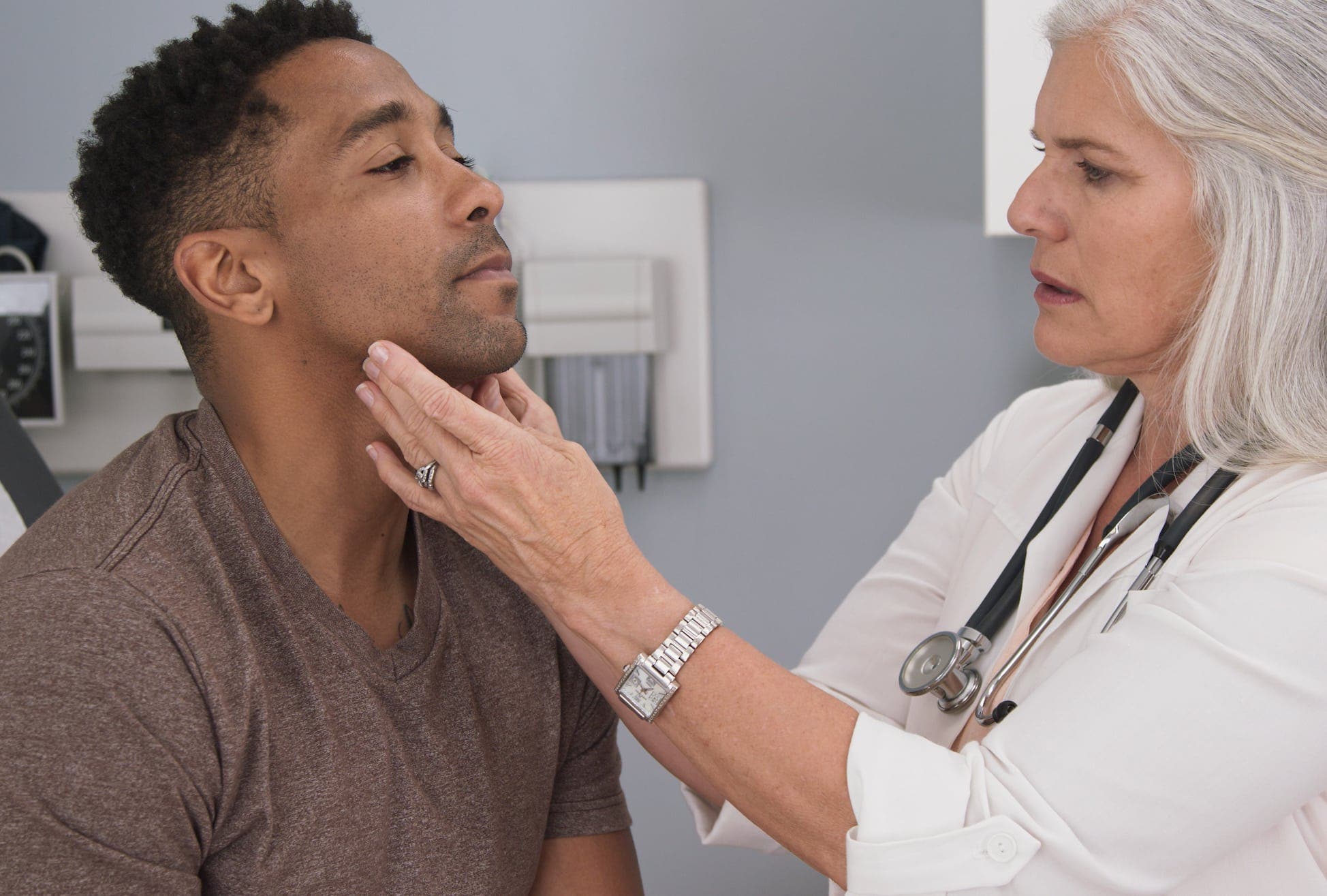 Doctor examining a man's throat for hypothyroidism