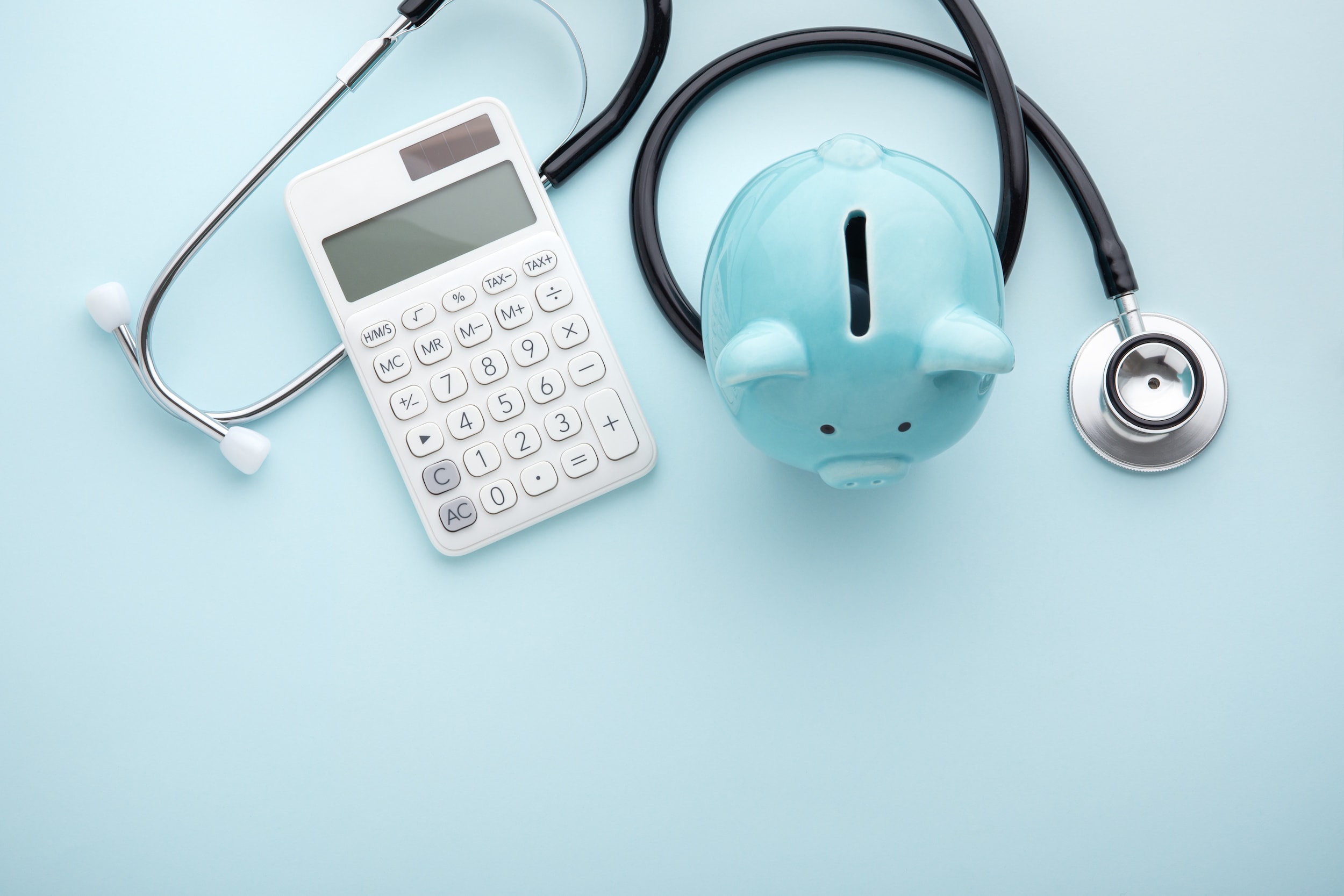 Piggy bank with stethoscope and calculator on blue background, health insurance coverage for fertility treatments