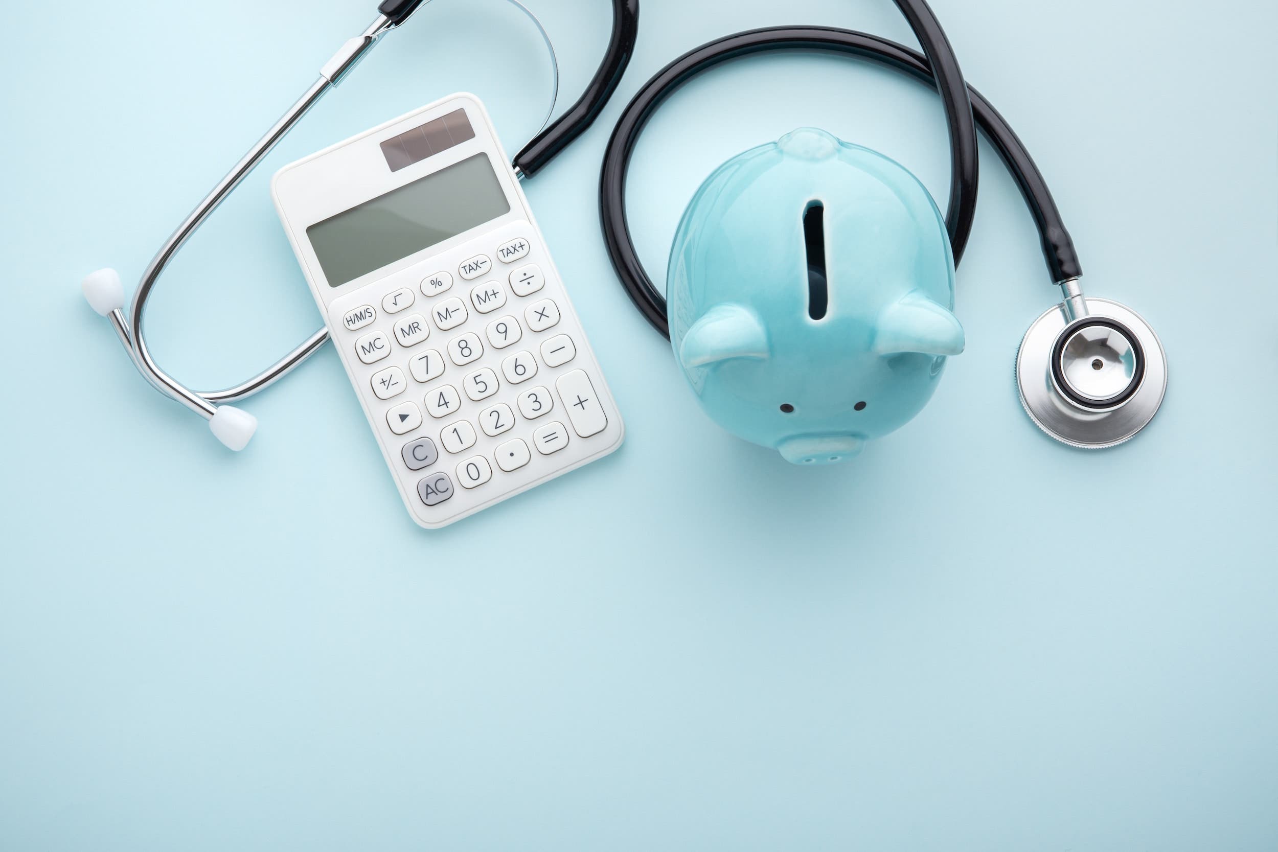 Piggy bank with stethoscope and calculator on blue background, health insurance coverage for fertility treatments