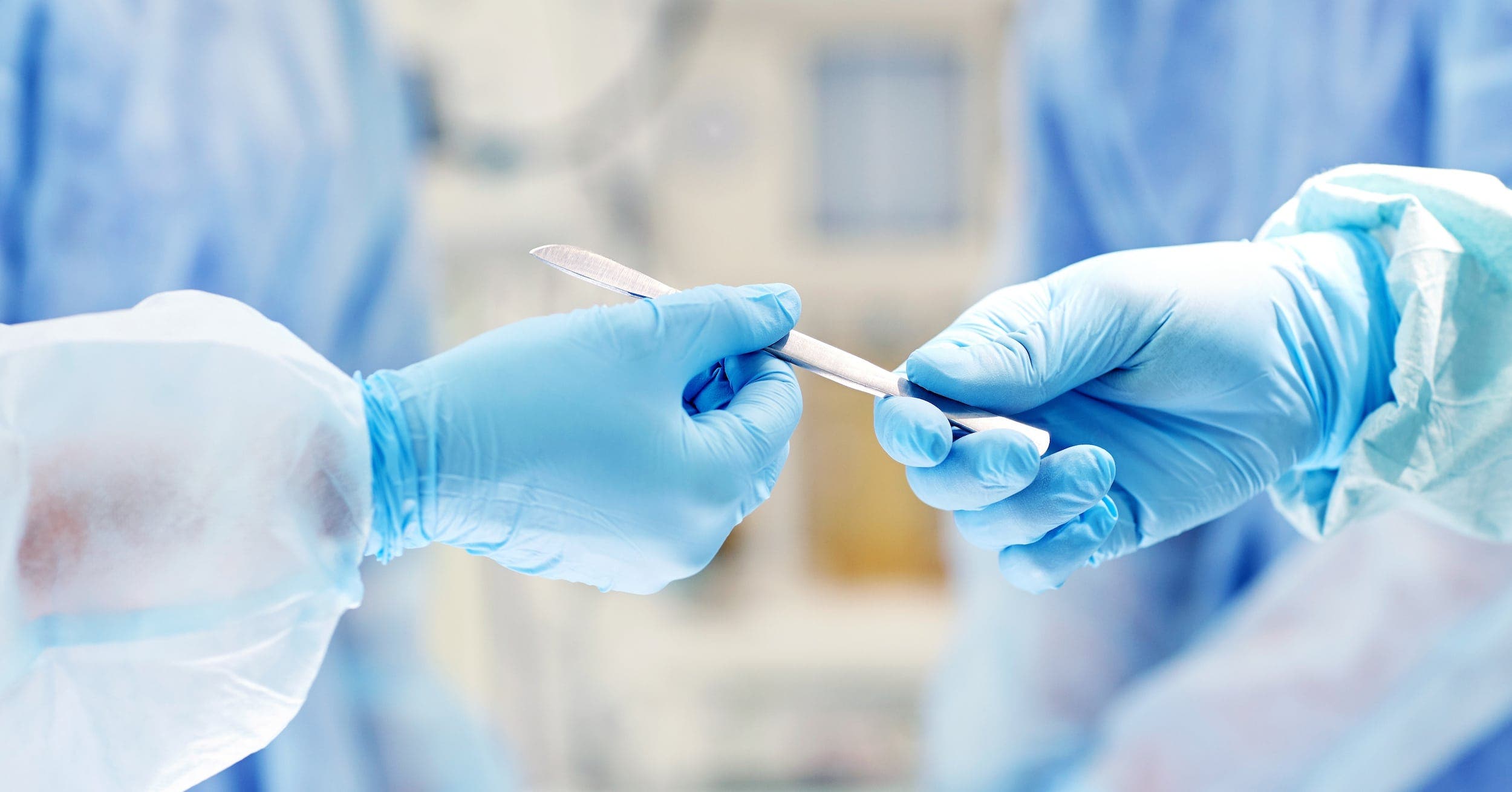 close up of hands with scalpel preparing for vasectomy