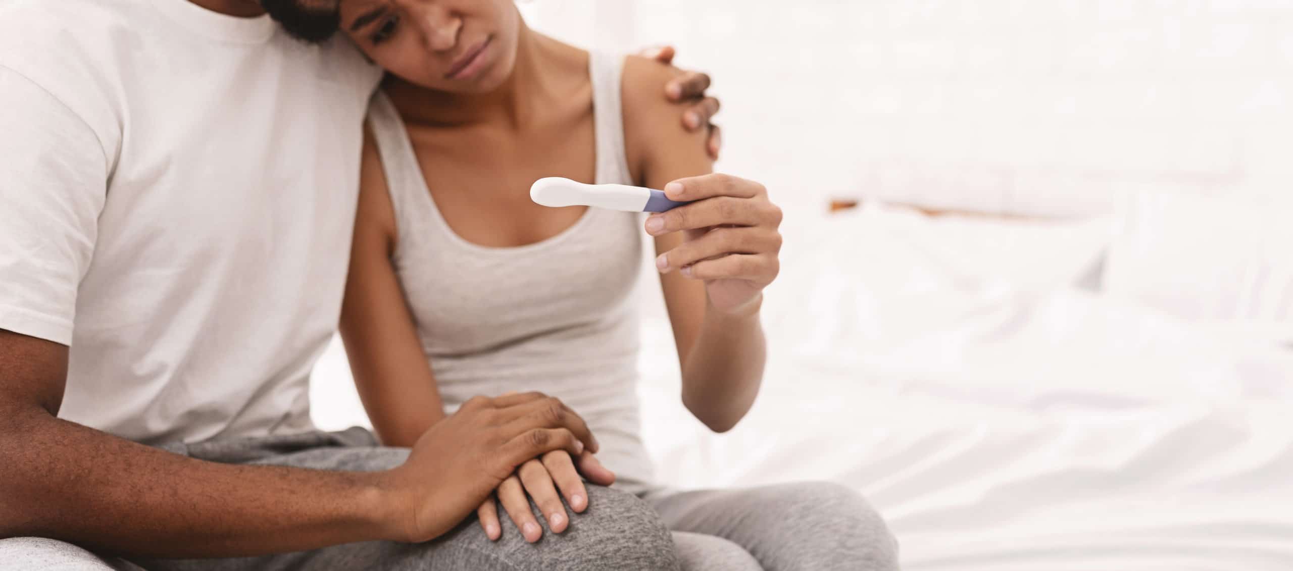 Couple looking at an at-home pregnancy test stick